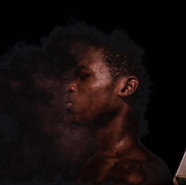 Profile portrait of a young man surrounded by dramatic smoke effects, showcasing expert photo editing.