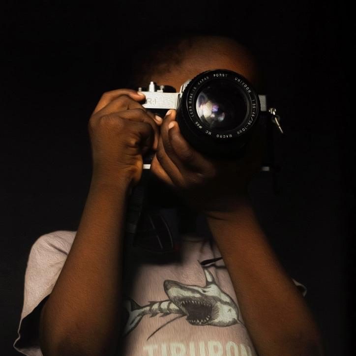 Close-up of a child holding a vintage camera, symbolising creativity and passion for photography.